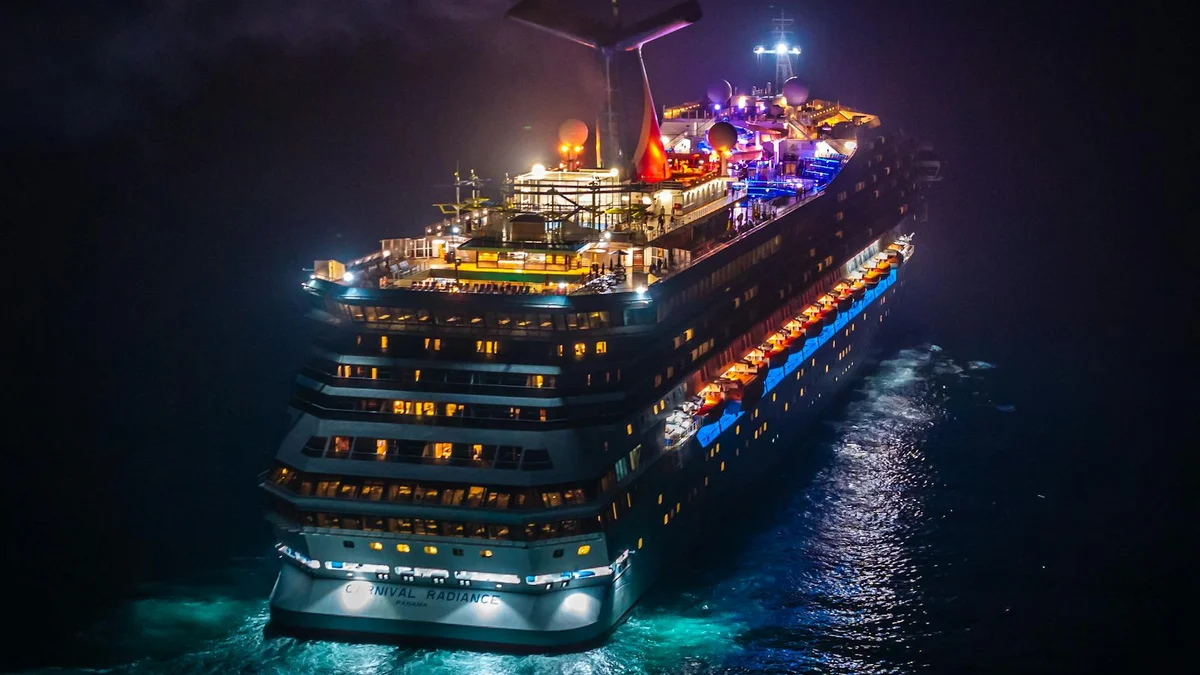 Crucero por la noche con la cubierta iluminada y reflejos en el agua
